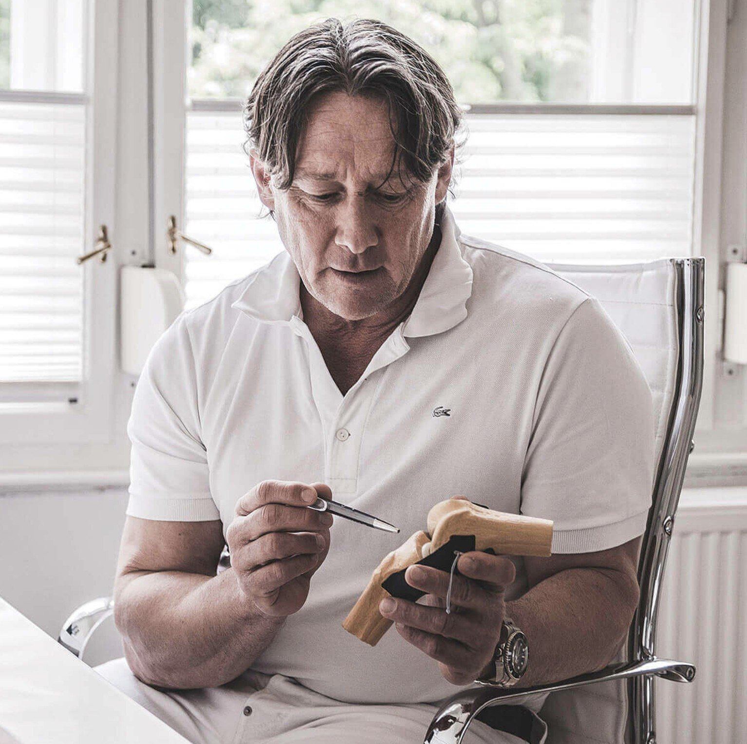 Dr. Jürgen Mandl mit einem Gelenkmodell in der Ordination