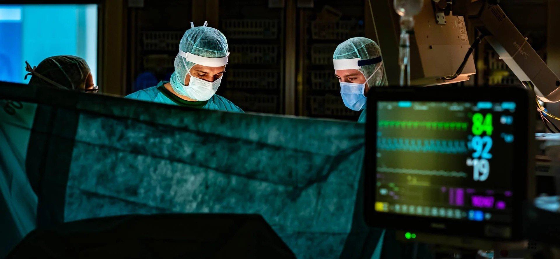Chirurgen im Operationssaal mit Patientenmonitor